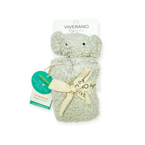 Grey teddy bear with curly texture, cream bow, and green tags on a white background.