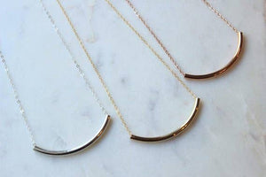 Laalee Jewelry curved tube necklace with sleek gold-tone design, showcasing smooth, modern jewelry style.