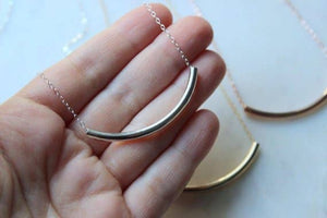 Laalee Jewelry curved tube necklace featuring sleek, modern design with smooth metal finish on a simple chain.
