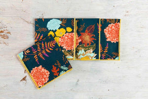 Set of four Dot and Army winter floral cloth dinner and cocktail napkins with festive floral patterns.