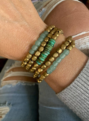 Turquoise glass and brass bracelet set by Nellie Pratt Artisan Jewelry, featuring multiple stacked bangles with vibrant turquoise stones.