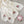 Cream knit blanket with pink floral patterns and a smiling pink flower plush toy beside it.