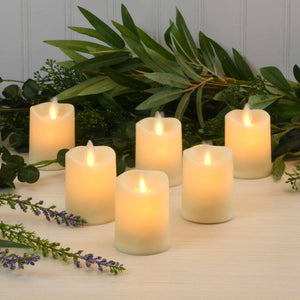 Set of six LumaBase LED votive candles with realistic flickering flames on a white surface, battery-operated for safe, ambient lighting.