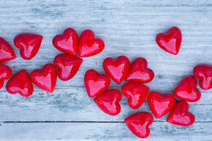Decorative glass pocket hearts in three color schemes, made by SHOPGIVECOURAGE, displayed in a close-up image.
