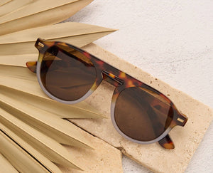 Peepers Neptune sunglasses with clear reading lenses, stylish round frame and dark tinted lenses for outdoor and reading use.