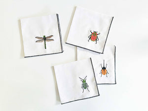 Set of four cocktail linen napkins with insect embroidery by Dot and Army, featuring detailed insect designs on elegant fabric