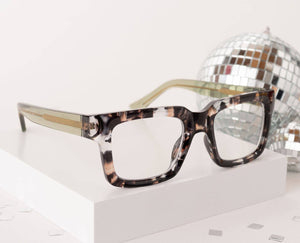 Peepers Spotlight reading glasses with clear lenses and stylish black frames, close-up of the eyewear on a white background.