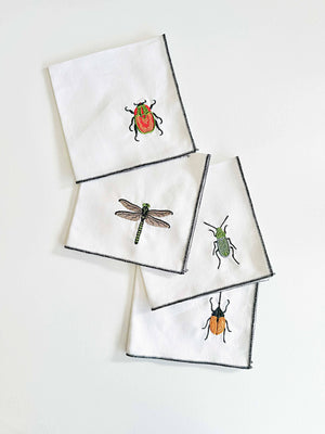 Set of four Dot and Army linen cocktail napkins with insect embroidery, featuring elegant linen fabric and intricate design.