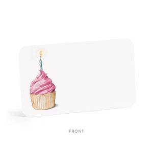 Pink cupcake with a lit candle on a white card with rounded corners.