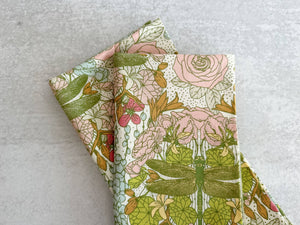Set of four Dragonfly Garden cloth dinner and cocktail napkins by Dot and Army, featuring floral and dragonfly patterns.