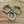 Three beaded bracelets with turquoise, white, and gold accents on a wooden surface.