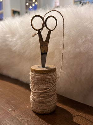 Small wooden spools with jute and scissors, decor-style kitchen accessories from CCOI, displayed on a rustic surface.