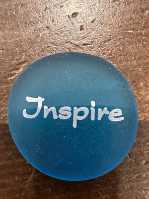 Imprinted glass word stones from SHOPGIVECOURAGE displayed in a bowl, featuring inspirational messages on clear, smooth stones.