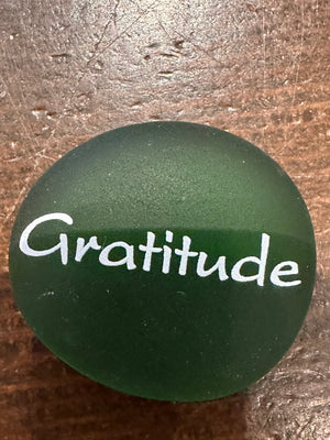 Imprinted glass word stones from SHOPGIVECOURAGE displayed in a bowl for decorative or inspirational purposes.