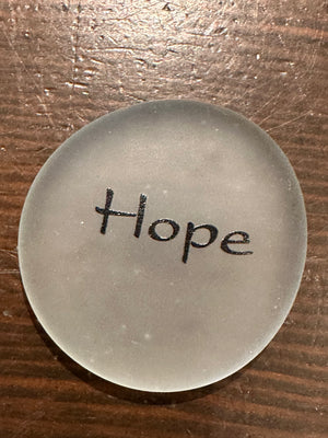 Sea stones with imprinted glass words from SHOPGIVECOURAGE displayed in a bowl for decorative or inspirational use.