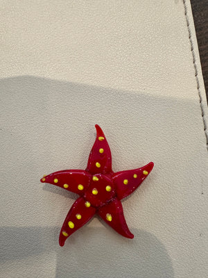 Miniature glass starfish figurine from SHOPGIVECOURAGE, decorative collectible with detailed, translucent glass design.