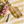 Bottle and tube on yellow-striped fabric with pink flowers and green foliage.