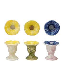 Stoneware flower-shaped taper candleholders by CCOI in three styles, featuring intricate designs and a decorative floral motif.