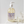 Clear soap bottle with purple text, white pump top, next to small clear glass bottles on white surface.