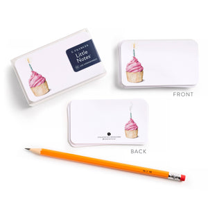 White note cards with pink cupcake design, front and back views, next to an orange pencil.