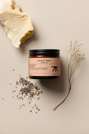 Sweet Bee Organics magnesium butter jar labeled "Sweet Sleep" for relaxing sleep aid, with natural ingredients visible on the packaging.