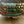 Turquoise glass and brass bracelet set by Nellie Pratt Artisan Jewelry with multiple bangles and intricate bead details.