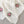 Cream knit blanket with pink flower patterns and diamond lace details, on a gray surface.