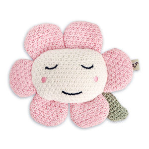 Crocheted flower toy with pink petals, white smiling face, closed eyes, and a small green leaf.