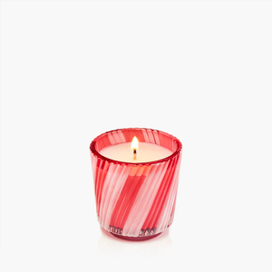 Red and white striped candle holder with a lit candle inside, against a plain white background.