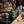 Green candles on a table, holiday gifts, wrapping paper, and a vintage red wagon in the background.
