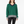 Woman in a green sweater with navy collar, gray cuffs and hem, wearing black pants on white background.