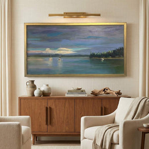 Framed seascape painting above a wooden sideboard with pottery, books, and a driftwood piece.