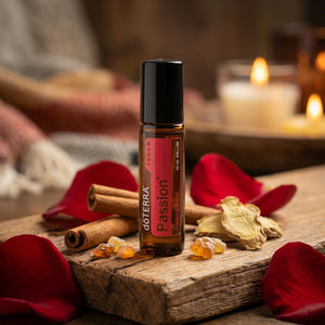 Aromatic oil bottle with cinnamon, ginger, and red petals; candles glow softly in the background.