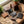Leather wallets on a wooden table, surrounded by plants, twine, tools, and a 