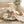 Two plush bunny rattles on a beige blanket near a crib, with wooden blocks and eucalyptus.