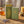 Green matchbox with gold bee design, open to reveal yellow-tipped matches, lavender, honey jar nearby.