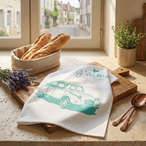 Baguettes in basket, lavender, towel with vintage car print on wooden board by sunny window.