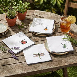 Set of four cocktail linen cloth napkins with insect embroidery by Dot and Army, featuring intricate insect designs on soft linen fabric.