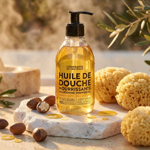 A bottle of nourishing shower oil on a stone with sponges and nuts, in warm sunlight.