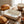 Bread, bowls, and eggs on a wooden table with a white baking dish reading 