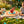 Paddle with red ball on string, orange and blue target design, confetti, child laughing in the background.