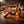 Four colorful spinning tops with sparks on a wooden table in a workshop setting.