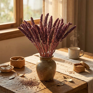Purple dried flowers in a rustic vase on a wooden table with a steaming cup and baskets.