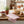 Rustic kitchen with bread on a board, a bowl of berries, rosemary plant, and striped cloth.