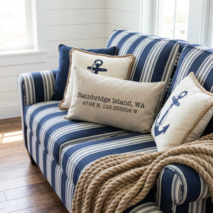 Nautical-themed blue striped couch with anchor pillows and a Bainbridge Island cushion.