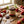 Jar of strawberry rhubarb preserve with scattered strawberries and rhubarb on a wooden table.