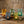 Five glass candle holders in blue, green, and amber glow on a rustic wooden table.