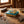 Key-shaped pocket knife on blue tin, surrounded by wood shavings on a wooden table.