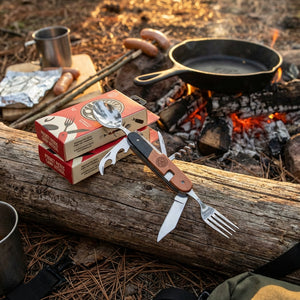 Fold-out camp utensil set from DM Merchandising with wooden handle and multiple tools, designed for outdoor picnics and camping.