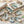 Decorative oyster shells with gold edges, painted with ocean designs on a textured white surface.